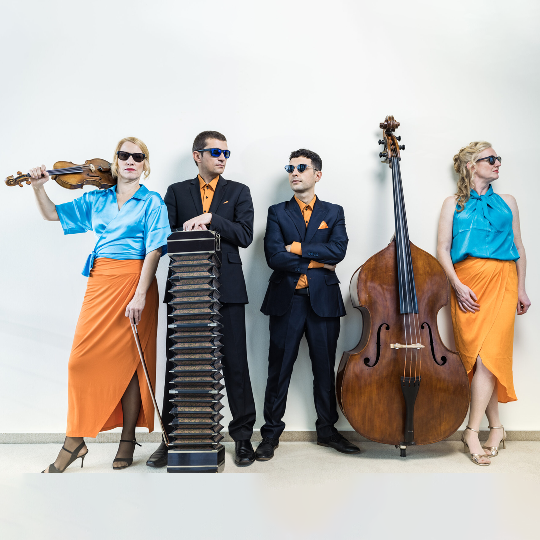 Vier Musiker stehen vor einer weißen Wand, tragen koordinierte blaue und orangefarbene Outfits und Sonnenbrillen. Einer hält eine Geige, ein anderer steht hinter einem Bandoneon, der dritte steht daneben, und der vierte lehnt sich an einen Kontrabass.