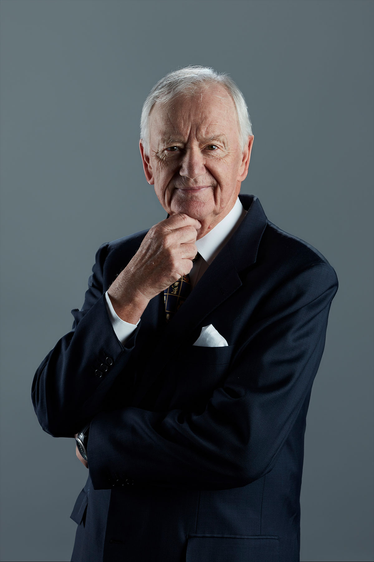 Porträt von Hans-Peter Porsche im dunklen Anzug vor grauem Hintergrund